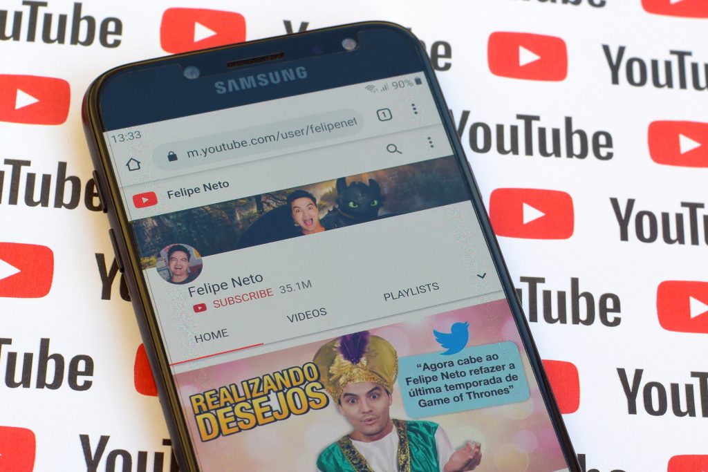 Felipe Neto official youtube channel on smartphone screen on paper youtube background